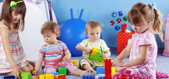 Toddlers playing with colorful building blocks