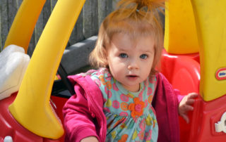 girl playing in toddler car