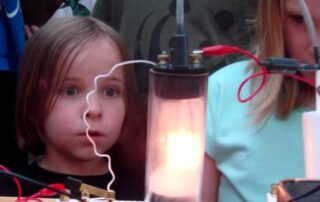young girl looking at electric light experiment
