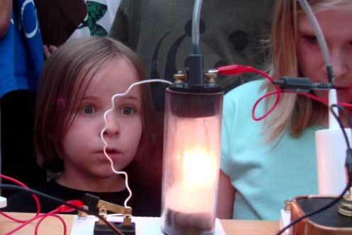 young girl looking at electric light experiment