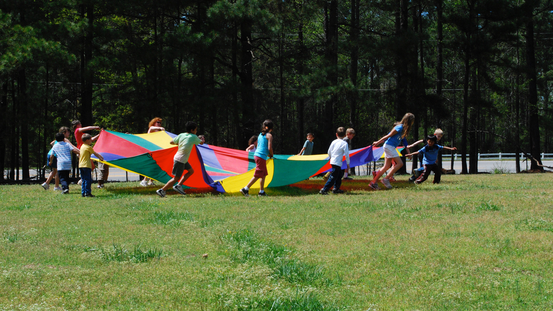 Children Pulling a Parachute Across a Field