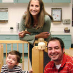 mom dad child kid toddler on play equipment inside classroom at school