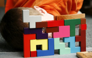 boy looking through montessori blocks colorful creative success