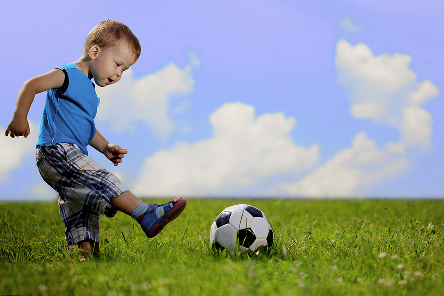 Image of family, mother and son playing ball in the park. Toddler playing soccer