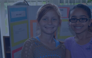 two girls in front of science boards at a science fair