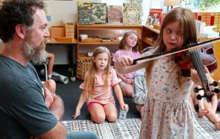 child with teacher playing the violin