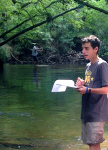 Student working on water studies at the school's creek