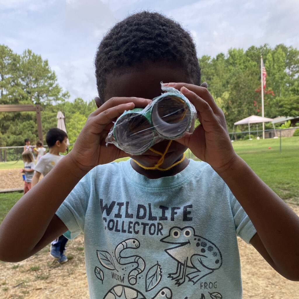 child looking through binoculars