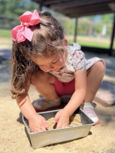 girl playing outdoors in sand