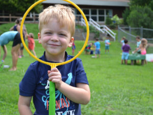 boy looking through bubble hoop outdoors