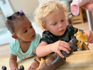 two toddlers playing with toy animals