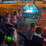 children around a campfire with teachers on a science night out event