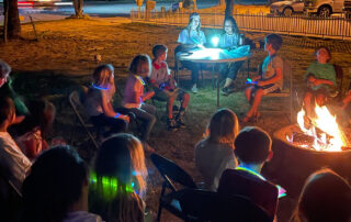 children around a campfire with teachers on a science night out event