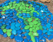 Blue and green painted rocks on ground