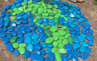 Blue and green painted rocks on ground