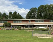 Two-story Montessori school building on a lawn with playground.
