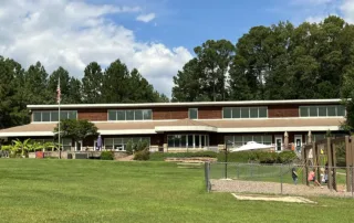 Two-story Montessori school building on a lawn with playground.