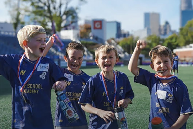 Elementary students celebrating soccer skills after training with Carolina Soccer Factory coaches.