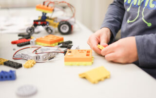 Student assembling a robotics project using RoboThink engineering kits.